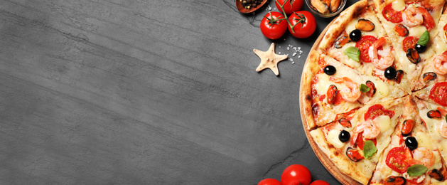 Image of Top view of hot delicious pizza on dark table, space for text. Banner design 