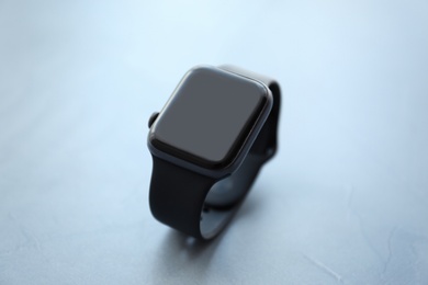 Stylish smart watch on grey stone table, closeup