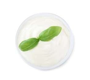 Delicious sour cream with basil in bowl on white background, top view