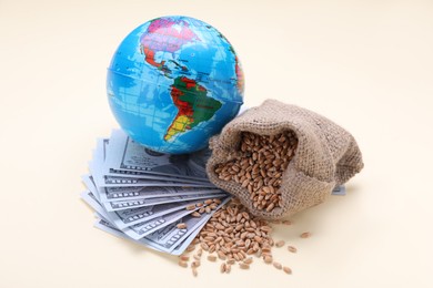 Import and export concept. Globe, bag of wheat grains and banknotes on beige background