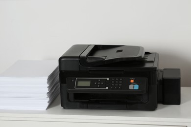 Photo of Modern printer and paper sheets on white table indoors