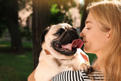Woman with cute pug dog outdoors on sunny day. Animal adoption