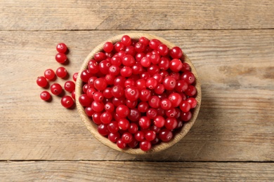 Ripe fresh cranberry on wooden table, flat lay