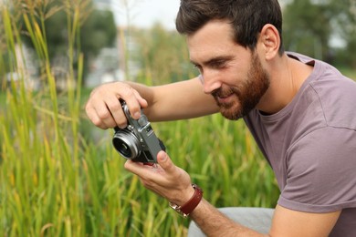 Photo of Man with camera taking photo outdoors. Interesting hobby