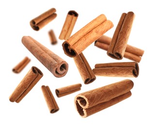Image of Aromatic cinnamon sticks falling on white background