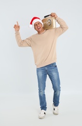 Emotional man with vintage radio on white background. Christmas music