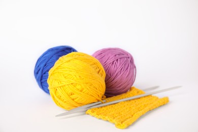 Soft woolen yarns, knitting and needles on white background