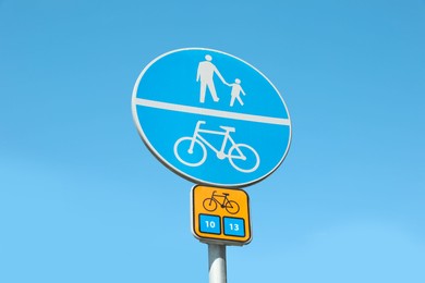 Different traffic signs against blue sky, low angle view