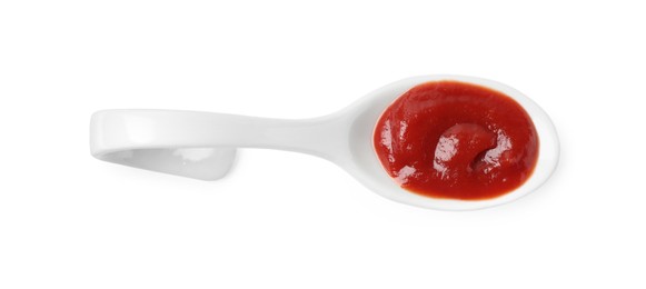 Photo of Ketchup in ceramic serving spoon isolated on white, top view
