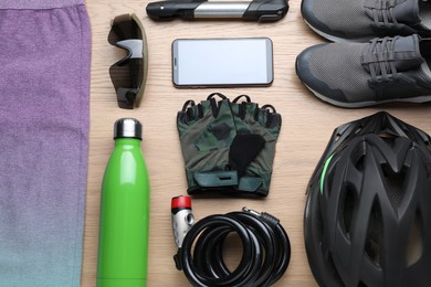 Flat lay composition with different cycling accessories on wooden background