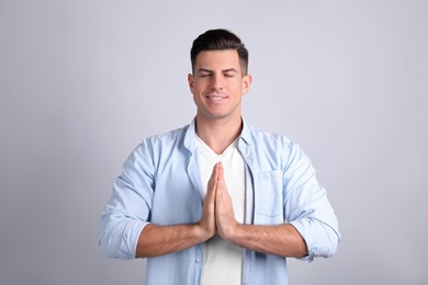 Man meditating on light background. Stress relief exercise