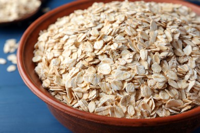 Bowl of oatmeal on blue table, closeup