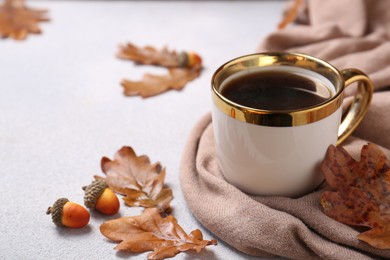 Photo of Composition with cup of hot drink and autumn leaves on light grey textured table, closeup. Space for text