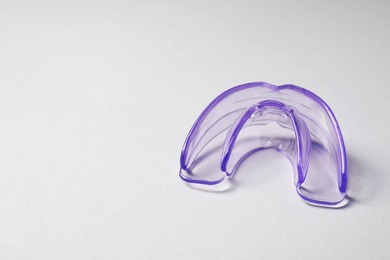 Photo of Transparent dental mouth guard on light background, space for text. Bite correction
