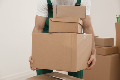 Man with cardboard boxes in room, closeup. Moving service