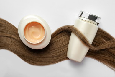 Natural cosmetic products and hair lock on white background, flat lay