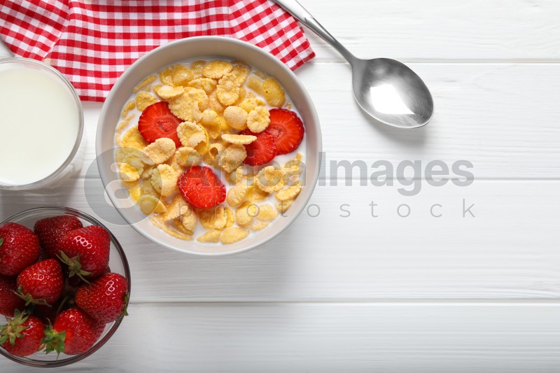Corn flakes with strawberries in bowl served on white wooden table, flat lay. Space for text