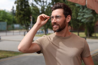 Handsome bearded man with glasses looking away outdoors