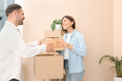 Photo of Happy couple unpacking box in new apartment. Moving day