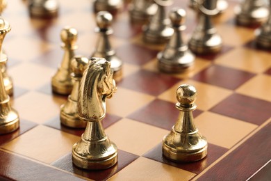 Wooden chessboard with game pieces, closeup view
