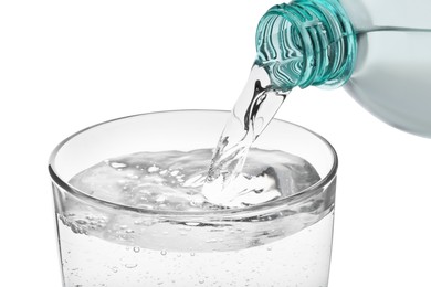 Pouring soda water from bottle into glass on white background, closeup