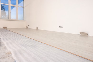 Light spacious room with unfinished laminate flooring