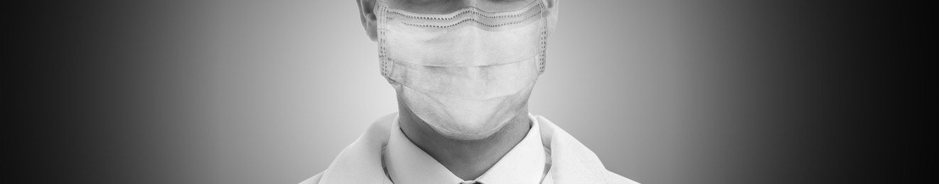 Closeup view of man wearing medical face mask on grey background, banner design. Black and white photography