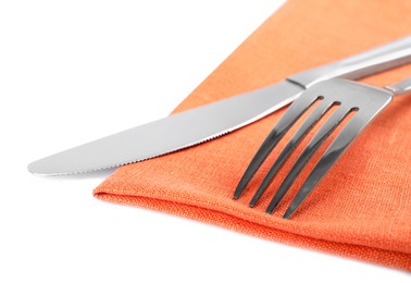 Orange napkin with fork and knife on white background, closeup
