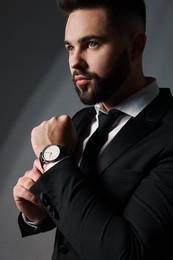 Handsome bearded man in stylish suit on grey background