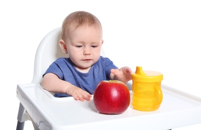 Adorable little child having breakfast in highchair against white background. Healthy baby food
