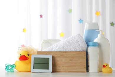 Photo of Towels, rubber ducks, hygrometer and baby care products on white table indoors