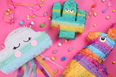 Photo of Different bright pinatas on pink background, flat lay