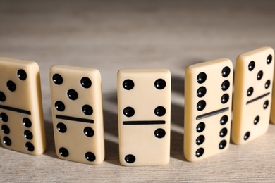 Classic domino tiles on wooden table, closeup
