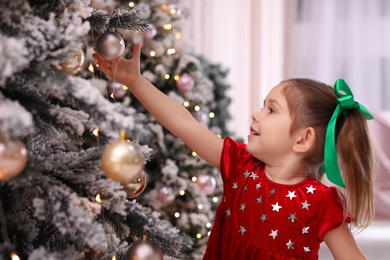 Cute little child near Christmas tree at home