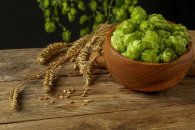Photo of Fresh green hops, wheat grains and spikes on wooden table