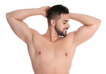 Young man showing hairless armpits after epilation procedure on white background