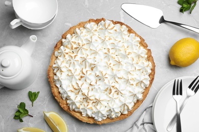 Flat lay composition with delicious lemon meringue pie on grey table