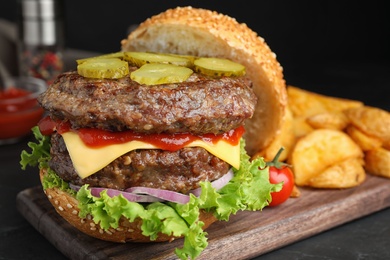 Delicious burger with meat cutlets on black table, closeup