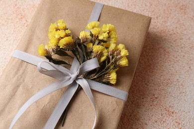 Book decorated with flowers on beige textured table, closeup
