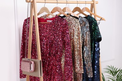 Photo of Rack with collection of stylish dresses in luxury showroom. Preparing for party