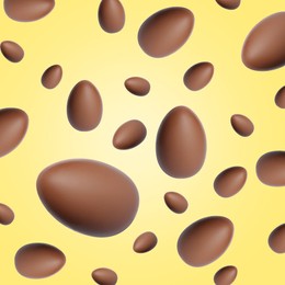 Image of Many chocolate eggs falling on pale light yellow background