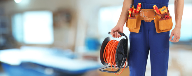 Image of Closeup view of electrician with tools indoors, space for text. Banner design