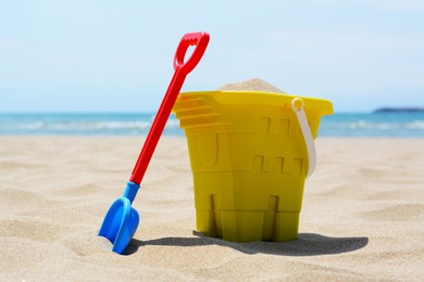 Plastic bucket and shovel on sand. Beach toys