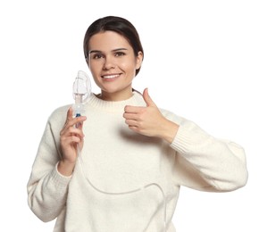 Happy young woman with nebulizer showing thumb up on white background