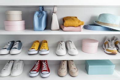 Photo of White shelving unit with collection of colorful sneakers and accessories