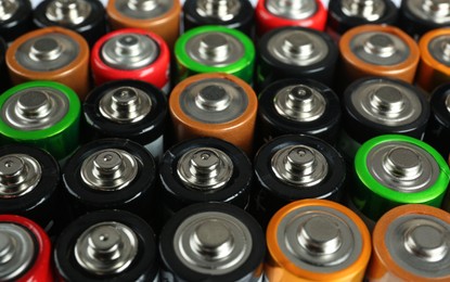 Many different batteries as background, closeup view