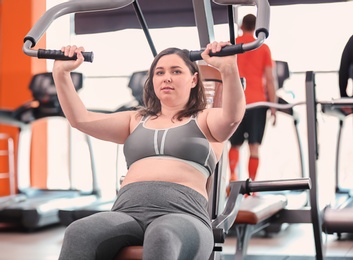 Overweight woman training in gym