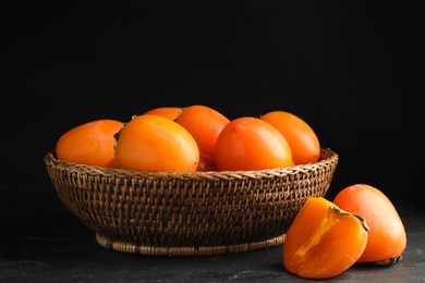 Delicious fresh persimmons on black slate table