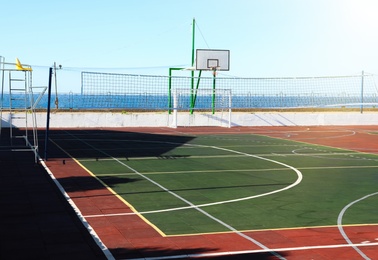 Empty multi-sport game court near sea on sunny day