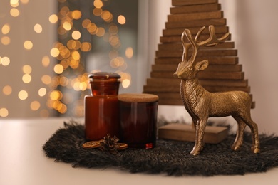 Composition with decorative Christmas tree and reindeer on light table, closeup